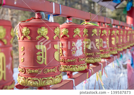Red Buddhist prayer wheels at Khoimorsky Datsan in Arshan, close up view 139587873