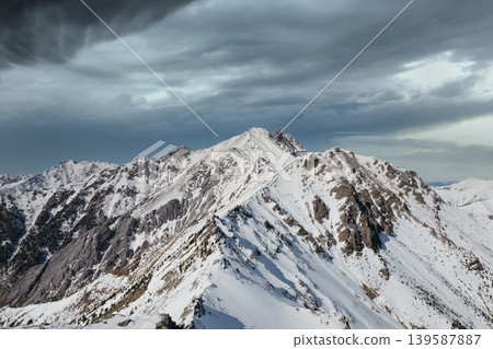 Snowy Galina Peak ridge above Arshan village under dramatic storm clouds 139587887