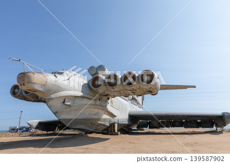 Abandoned Soviet ekranoplan on sandy shore under clear blue sky, Dagestan Abandoned Soviet ekranoplan on sandy shore under clear blue sky, Dagestan 139587902