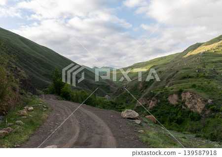 Mountain dirt road to Mount Shalbuzdag through green valley in Dagestan Mountain dirt road to Mount Shalbuzdag through green valley in Dagestan 139587918