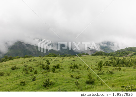 Misty mountain meadow landscape in Dagestan with low clouds and green hills Misty mountain meadow landscape in Dagestan with low clouds and green hills 139587926