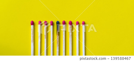 Success, defeat, achievement. The concept of happiness. Matches on a yellow background. Burnt dark match among normal matches. Burning match fire to its neighbors, a metaphor for ideas and inspiration Success, defeat, achievement. The concept of happiness. Matches on a yellow background. Burnt dark match among normal matches. Burning match fire to its neighbors, a metaphor for ideas and inspiration 139588467