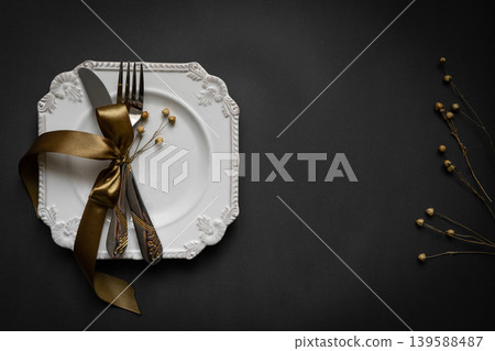 Romantic tabble setting with ribbon, plates, cutlery on black background. Empty plate. Mockup design layout for your text. Love romantic concept. Copy space. Top view. Flat lay. Romantic tabble setting with ribbon, plates, cutlery on black background. Empty plate. Mockup design layout for your text. Love romantic concept. Copy space. Top view. Flat lay. 139588487