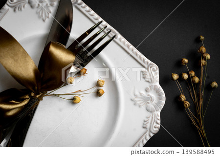 Romantic tabble setting with ribbon, plates, cutlery on black background. Empty plate. Mockup design layout for your text. Love romantic concept. Copy space. Top view. Flat lay. Romantic tabble setting with ribbon, plates, cutlery on black background. Empty plate. Mockup design layout for your text. Love romantic concept. Copy space. Top view. Flat lay. 139588495