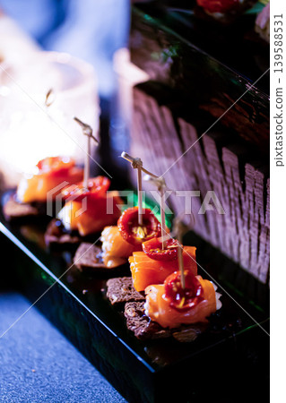 Pumpernickel bread sandwich snack with cured smoked salmon and fresh avocado served as close-up on a wooden cutting board 139588531