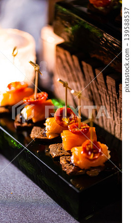 Pumpernickel bread sandwich snack with cured smoked salmon and fresh avocado served as close-up on a wooden cutting board 139588537