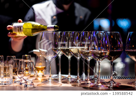 Waiter pouring wine into wineglass. Waiter work. Sommelier pours alcoholic drink Waiter pouring wine into wineglass. Waiter work. Sommelier pours alcoholic drink 139588542
