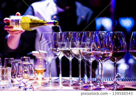 Waiter pouring wine into wineglass. Waiter work. Sommelier pours alcoholic drink Waiter pouring wine into wineglass. Waiter work. Sommelier pours alcoholic drink 139588543