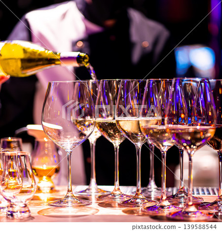 Waiter pouring wine into wineglass. Waiter work. Sommelier pours alcoholic drink Waiter pouring wine into wineglass. Waiter work. Sommelier pours alcoholic drink 139588544