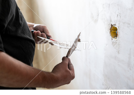 Happy worker man making wall in the room by hand spatula repair Happy worker man making wall in the room by hand spatula repair 139588568