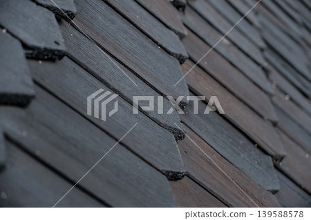 shingles on the roof. Wooden roof, shingled roof. Wooden tile. Roof of complex construction with dormer windows shingles on the roof. Wooden roof, shingled roof. Wooden tile. Roof of complex construction with dormer windows 139588578
