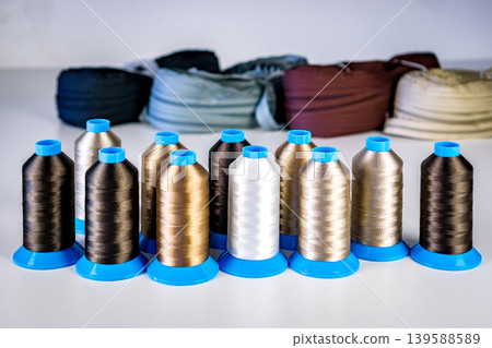 Multicolored spools thread. Spools of multi-colored threads lies on white table, close-up shot photo Multicolored spools thread. Spools of multi-colored threads lies on white table, close-up shot photo 139588589
