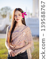 Trendy Thai fashion woman wearing a traditional Sabai paired with denim jeans at temple, reflecting the growing fashion trend in Thailand that blends cultural heritage with contemporary street style. 139588767