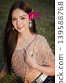 Trendy Thai fashion woman wearing a traditional Sabai paired with denim jeans at temple, reflecting the growing fashion trend in Thailand that blends cultural heritage with contemporary street style. 139588768