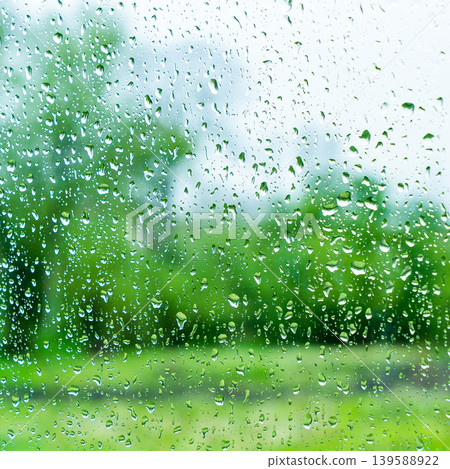 A rainy day window view. Rain drops on window. Condensed rain drop on the car glass window on a rainy day. Dew moisture condensation on wet mirror background. Fresh weather. Water raindrop bg A rainy day window view. Rain drops on window. Condensed rain drop on the car glass window on a rainy day. Dew moisture condensation on wet mirror background. Fresh weather. Water raindrop bg 139588922