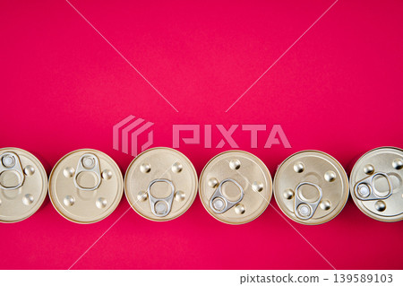 Row of metal tin cans on pink background 139589103