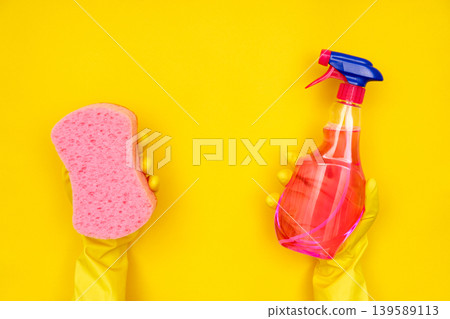 Hands in yellow gloves holding sponge and spray Hands in yellow gloves holding sponge and spray 139589113