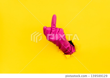 Hand in pink glove showing middle finger gesture 139589129