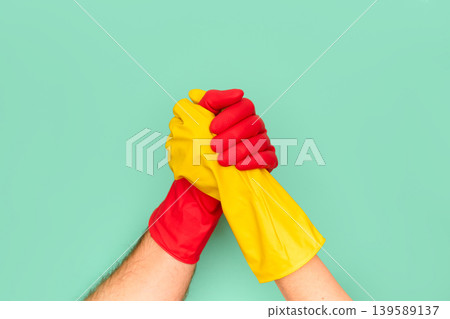 Teamwork concept with red and yellow cleaning gloves 139589137