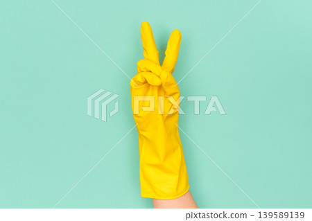 Hand in yellow cleaning glove showing peace victory sign Hand in yellow cleaning glove showing peace victory sign 139589139