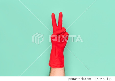 Hand in red cleaning glove showing peace victory sign Hand in red cleaning glove showing peace victory sign 139589140