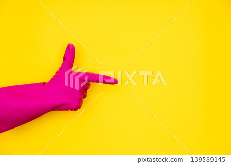 Hand in pink cleaning glove pointing at copy space Hand in pink cleaning glove pointing at copy space 139589145