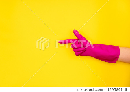 Hand in pink cleaning glove pointing at copy space Hand in pink cleaning glove pointing at copy space 139589146