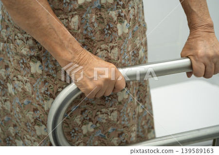 Asian elderly woman patient use handrail safety in toilet support rail in bathroom. Asian elderly woman patient use handrail safety in toilet support rail in bathroom. 139589163