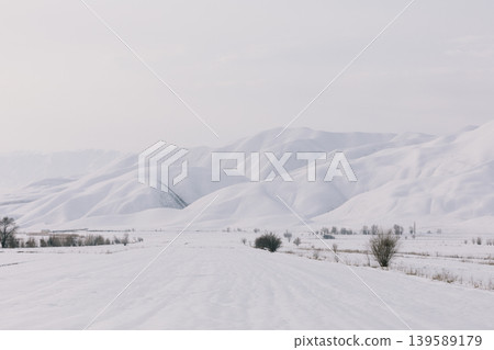 Snowy valley and mountain range landscape near Toktogul in Kyrgyzstan Snowy valley and mountain range landscape near Toktogul in Kyrgyzstan 139589179