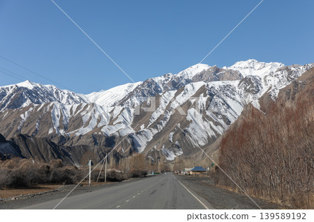 Scenic Pamir Highway road leading to snowcapped mountains in Kyrgyzstan 139589192