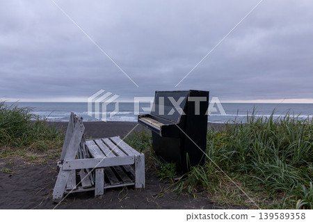 Abandoned piano and wooden bench on Khalaktyrsky Beach under stormy sky 139589358
