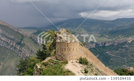 Gunib fortress stone wall ruins on mountain ridge with stormy sky, Gunib village Gunib fortress stone wall ruins on mountain ridge with stormy sky, Gunib village 139589438