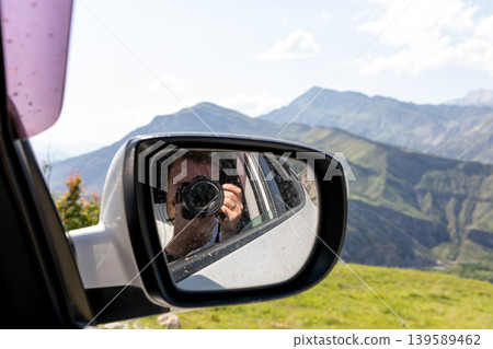 Photographer in car side mirror with Caucasus mountains view, Dagestan road trip 139589462