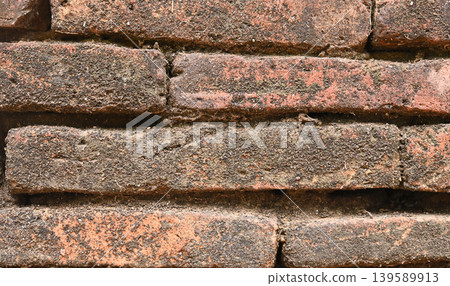 Old orange brick wall texture with vintage character and natural weathered details. Perfect background for design, architecture, rustic themes, or urban style projects.. 139589913