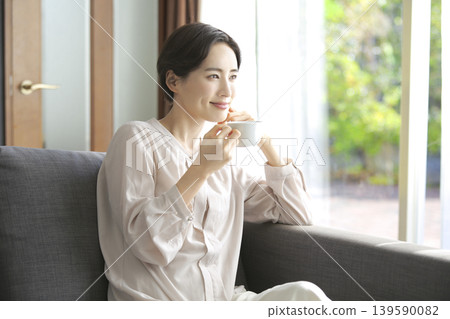 A woman drinking coffee: A peaceful moment in her everyday life. A woman drinking coffee: A peaceful moment in her everyday life. 139590082