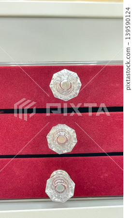 Close up of a red velvet jewelry organizer with three drawers and elegant faceted crystal handles Close up of a red velvet jewelry organizer with three drawers and elegant faceted crystal handles 139590124