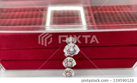 Front view of a red velvet jewelry organizer with a clear acrylic lid and three drawers featuring crystal handles Front view of a red velvet jewelry organizer with a clear acrylic lid and three drawers featuring crystal handles 139590128
