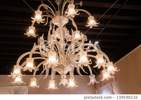 Vintage Murano glass chandelier illuminating classic European interior space Vintage Murano glass chandelier illuminating classic European interior space 139590216