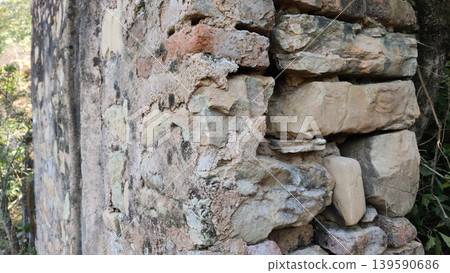 Ancient stone wall with moss and broken mortar Ancient stone wall with moss and broken mortar 139590686