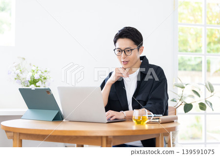 Teleworking: A man working from home. 139591075