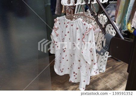 嬰兒衣服正在洗。嬰兒衣服掛在衣架上。有碎花和波點圖案。 嬰兒衣服正在洗。嬰兒衣服掛在衣架上。有碎花和波點圖案。 139591352