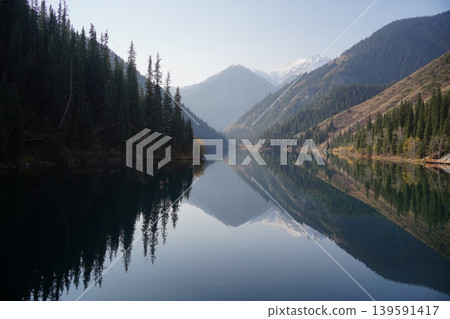 Kolsai Lake in Kazakhstan with forest and mountains reflecting in water Kolsai Lake in Kazakhstan with forest and mountains reflecting in water 139591417