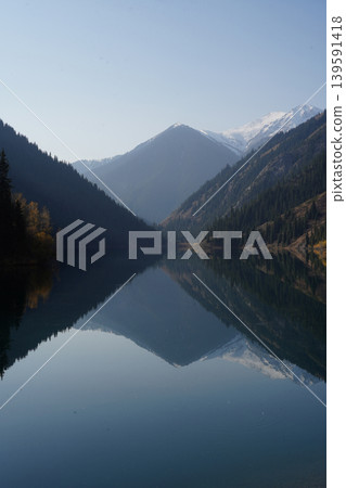 Kolsai Lake in Kazakhstan with forest and mountains reflecting in water 139591418