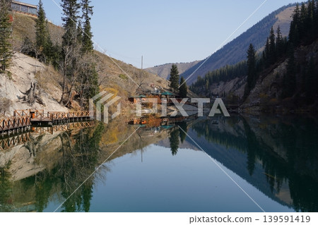 Kolsai Lake in Kazakhstan with forest and mountains reflecting in water Kolsai Lake in Kazakhstan with forest and mountains reflecting in water 139591419