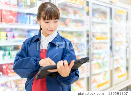 Women manage inventory using tablets 139591507