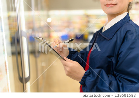 Female clerk working in a supermarket Female clerk working in a supermarket 139591588