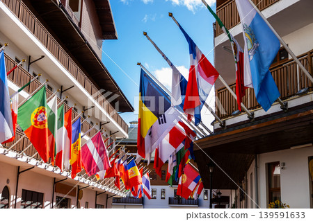 Colorful international flags on building exteriors against blue sky Colorful international flags on building exteriors against blue sky 139591633