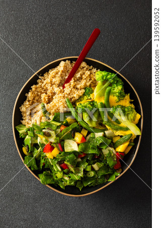 This healthy breakfast consists of a quinoa bowl served with boiled eggs, green beans, and broccoli, alongside a fresh salad. It offers a nutritious start to the day This healthy breakfast consists of a quinoa bowl served with boiled eggs, green beans, and broccoli, alongside a fresh salad. It offers a nutritious start to the day 139592052