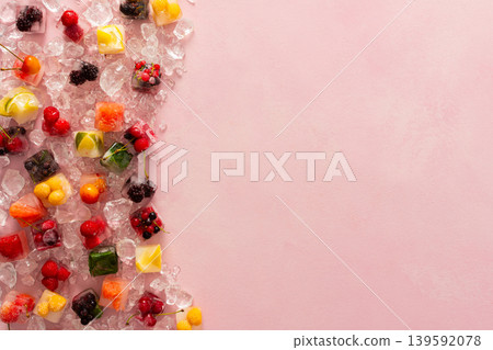 Pink background with ice cubes with frozen berries and fruits and mint Pink background with ice cubes with frozen berries and fruits and mint 139592078