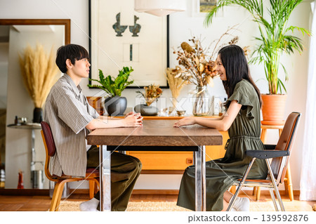 A conversation between a man and a woman facing each other in a brightly lit room. A conversation between a man and a woman facing each other in a brightly lit room. 139592876